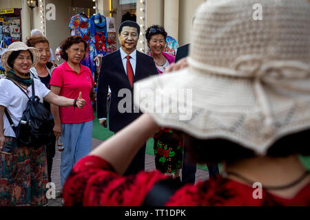 Les touristes chinois photographiés contre le portrait de dirigeant chinois Xi Jinping sur Arbat street dans le centre de Moscou, Russie Banque D'Images