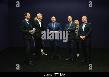 Directeur mondial de l'Art Basel Marc Spiegler (centre) de discuter d'une pièce d'art par l'artiste italien Lucio Fontana avec un groupe de clients VIP à la 49e Annual Art Basel Art fair à Bâle. Banque D'Images