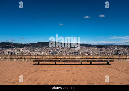 Vue grand angle de Barcelone, photo de paysage urbain depuis le haut du château de Montjuic, mur de pierre et des bancs de l'avant-plan, compo horizontale Banque D'Images