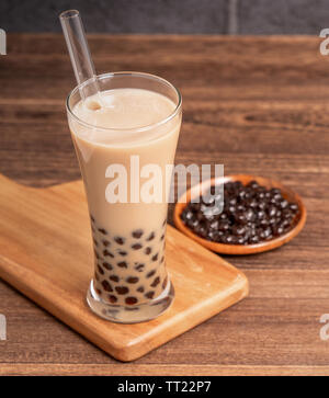 Taiwan populaires verre - bubble tea au lait avec des perles de tapioca balle en verre à boire et de la paille, table en bois brique gris background, Close up, copy space Banque D'Images