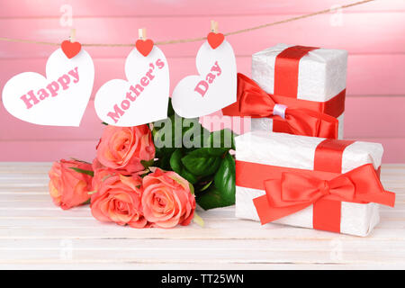 Happy Mothers Day message écrit sur papier coeurs de fleurs sur fond rose Banque D'Images