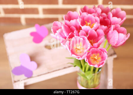 La composition avec bouquet de tulipes dans un vase, sur l'échelle, sur fond de mur Banque D'Images