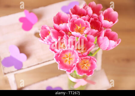 La composition avec bouquet de tulipes dans un vase, sur l'échelle, sur fond de mur Banque D'Images