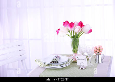 Nouvelle table et chaises avec des couverts sur fond clair Banque D'Images