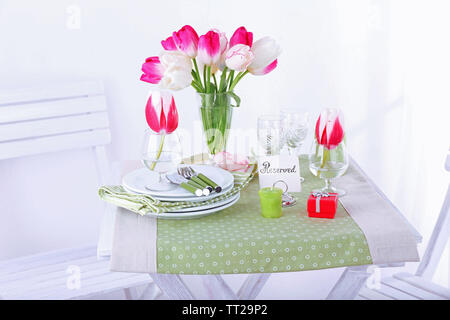 Nouvelle table et chaises avec des couverts sur fond clair Banque D'Images