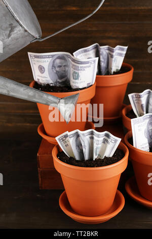 Concept d'entreprise : la croissance de l'argent dans les pots sur la table Banque D'Images