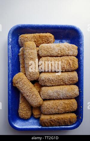 Boîte de poisson congelé doigts sur fond blanc Banque D'Images