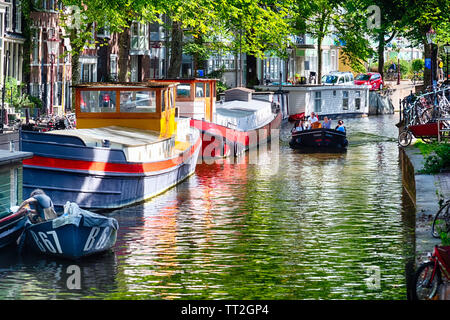 Petit Canal avec maison barges et un bateau d'excursion, Amsterdam, Pays-Bas Banque D'Images