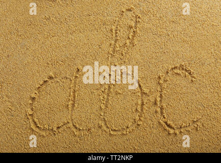 Lettres Alphabet écrit sur du sable de plage humide Banque D'Images