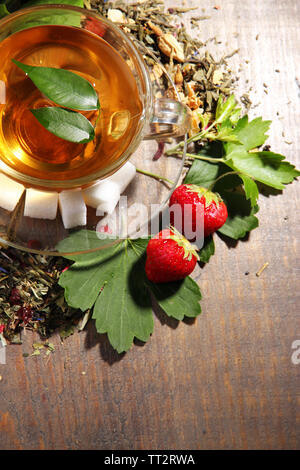 Composition avec fleurs, des herbes et des fruits secs ingrédients pour plateau et tasse en verre, sur la couleur de fond de bois Banque D'Images