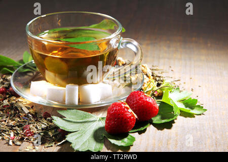 Composition avec fleurs, des herbes et des fruits secs ingrédients pour plateau et tasse en verre, sur la couleur de fond de bois Banque D'Images