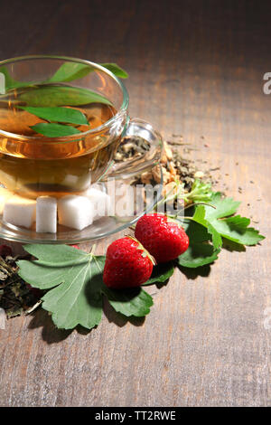 Composition avec fleurs, des herbes et des fruits secs ingrédients pour plateau et tasse en verre, sur la couleur de fond de bois Banque D'Images