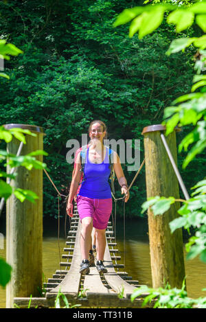 Un groupe de randonneurs traverser une petite passerelle au-dessus de la rivière Wertach près du village de Wald dans l'Allgäu Banque D'Images