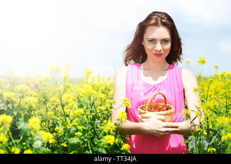 Belle Jeune femme tenant panier en osier avec les cerises au domaine Banque D'Images