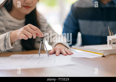 Un architecte à l'aide de compas pour tracer et mesurer le dessin d'atelier in office Banque D'Images