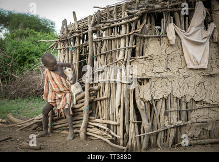 Même, la Tanzanie, le 5 juin, 2019 : garder le bébé garçon Maasai chèvres d'échapper à leur maison Banque D'Images