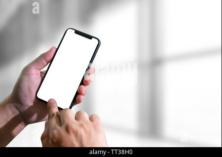 Immersive mains tenant le téléphone mobile à l'écran vide Banque D'Images