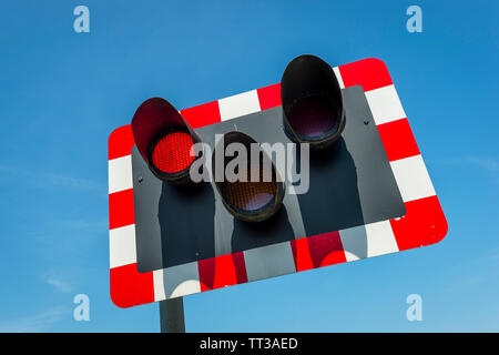 Signal rouge clignotant sur l'approche d'un passage à niveau au Royaume-Uni. Banque D'Images