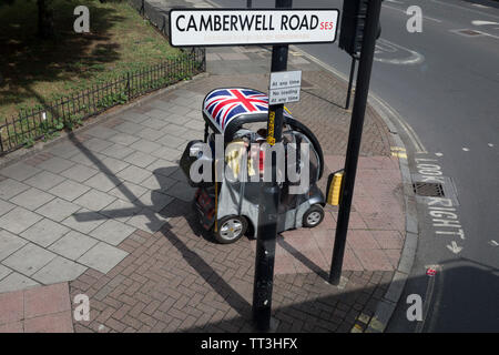 Une personne handicapée entraîne son scooter de mobilité sur la chaussée sur la Camberwell Road à Southwark, le 11 juin 2019, dans le sud de Londres, en Angleterre. Banque D'Images
