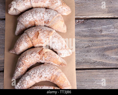 Bagels savoureux avec du sucre en poudre, sur fond de bois Banque D'Images