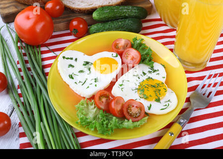 Oeufs brouillés aux légumes et jus servi dans la plaque sur nappes Banque D'Images