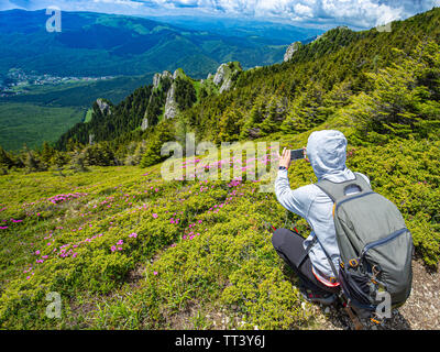 Vue arrière de la prise de photo sur blogger femme sur smartphone randonnée découvrez la nature en vacances Banque D'Images