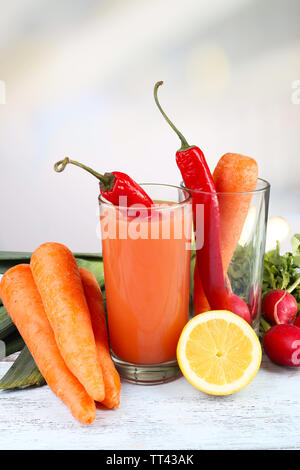 Verre de jus de carotte avec des légumes sur la table en bois Banque D'Images