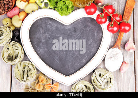 Composition des pâtes colorées, tomates fraîches, persil sur fond de bois Banque D'Images