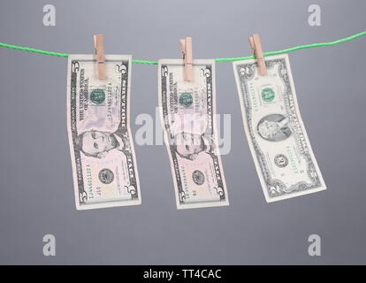 Dollar bills hanging sur corde attachée avec des pinces à linge. Le blanchiment de l'concept. Isolé sur fond blanc. Banque D'Images