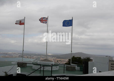 Drapeaux sur le sommet de Gibraltar rocher vue haute vue vent point de vue ville ville haut de l'UE drapeau militaire européen pôle ciel temps gris terne Banque D'Images