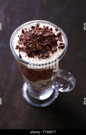 Yogourt, crème au chocolat, chocolat et muesli servis en verre sur fond de bois Banque D'Images