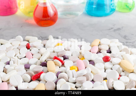 Une grande variété de pilules médicinales sur l'arrière-plan de fioles et flacons remplis de liquide Banque D'Images