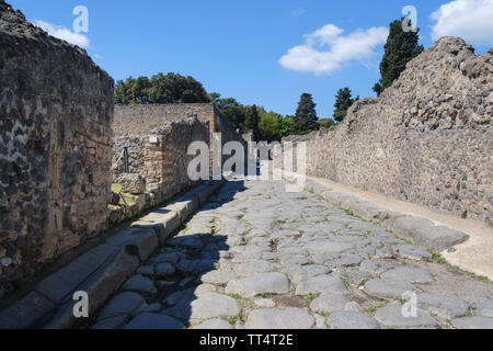 Ruines et rue pavée, dans les fouilles archéologiques de l'ancienne ville romaine de Pompéi en Campanie près de Naples, dans le sud de l'Italie Banque D'Images