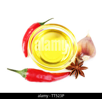 Des produits naturels faits à l'huile d'olive infusée dans bol en verre avec piment rouge, l'ail isolated on white Banque D'Images