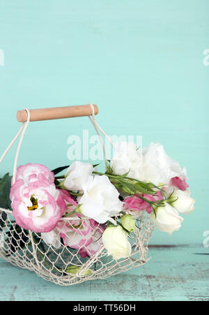 Belle eustoma fleurs dans le panier, sur fond de bois Banque D'Images