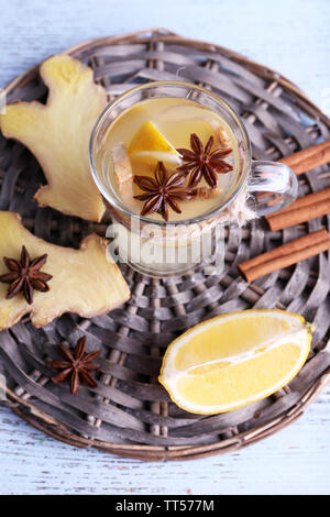 Tasse de boisson au gingembre avec du citron sur le tapis en osier sur fond de bois Banque D'Images