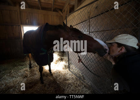 États-unis - 11 Avril 2016 : Eva Smithwick obtient un baiser de son cheval 'Rutledge'. Smithwick est le propriétaire de Sunny Bank Farm La ferme équestre près de Mid Banque D'Images