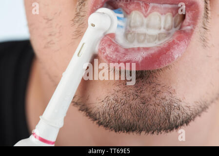 Le brossage des dents avec une brosse à dents électrique vue rapprochée Banque D'Images