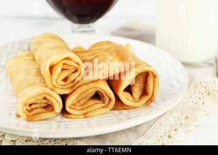 Plateau de crêpes et de confiture de petits fruits dans bol en verre, verre de lait sur fond de bois Banque D'Images