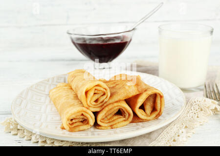 Plateau de crêpes et de confiture de petits fruits dans bol en verre, verre de lait sur fond de bois Banque D'Images