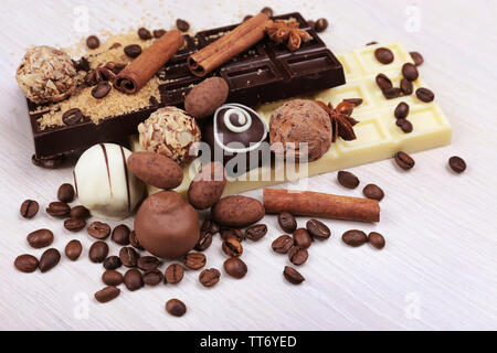 Le sucre et les grains de café renversé avec des chocolats sur fond de bois Banque D'Images