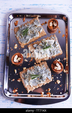 Croustillant de fromage bleu et branches de romarin sur le plateau métallique et la couleur de fond de table en bois Banque D'Images