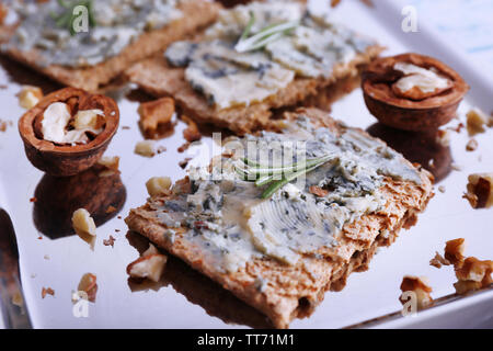 Croustillant de fromage bleu, noix et branches de romarin sur le plateau métallique et la couleur de fond de table en bois Banque D'Images