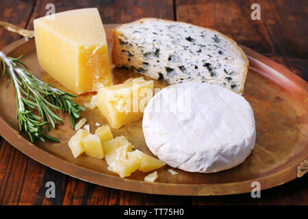 Différents types de fromage sur le plateau métallique et l'arrière-plan de table en bois Banque D'Images