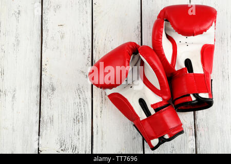 Paire de gants de boxe sur la couleur de fond de bois Banque D'Images