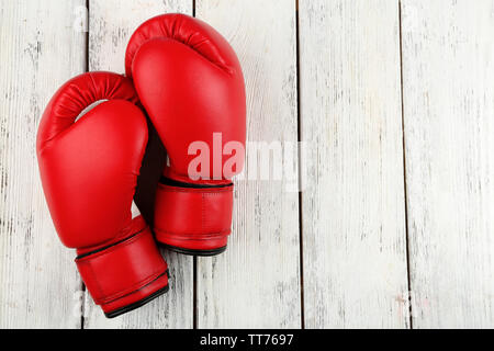 Paire de gants de boxe sur la couleur de fond de bois Banque D'Images