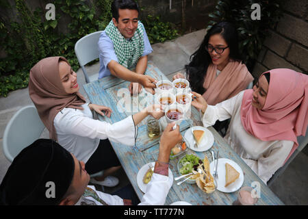 Vue de dessus d'un groupe des amis prenant le thé grillé au coin de table pendant le ramadan celebration Banque D'Images