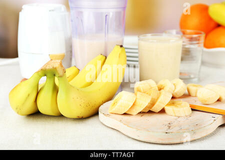 Tranches de banane sur une planche à découper, sur fond de bois Banque D'Images