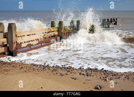 Vagues se brisant contre un brise-lames de bois à l'Est de la côte de Norfolk à Panier vide, Happisburgh, Norfolk, Angleterre, Royaume-Uni, Europe. Banque D'Images