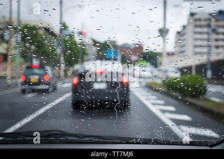 Journée pluvieuse et sombre sur la route avec des voitures et de la circulation et de la pluie est concentré sur le pare-brise de la voiture. Banque D'Images